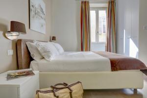 ein Schlafzimmer mit einem weißen Bett und einem Fenster in der Unterkunft Colosseo Gardens - My Extra Home in Rom