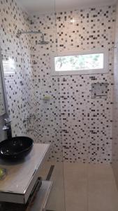 La salle de bains est pourvue d'une douche en verre et d'un lavabo. dans l'établissement dolce casa 2, à San Clemente del Tuyú