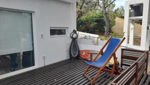 a blue chair sitting on a deck with a window at dolce casa 2 in San Clemente del Tuyú