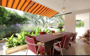 a dining room with a table and some plants at Amphora Deluxe in Vrboska