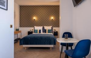 - une chambre avec un lit, une table et des chaises dans l'établissement Mijo's Appartements Hôtel, à Fontenay-sous-Bois