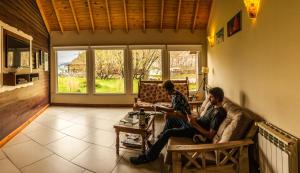 two men sitting on a couch in a living room at Patagonia Hostel in El Chalten