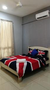a bed with a red white and blue comforter at Nana OWL Homestay A & B Roomstay C & D in Kemasik