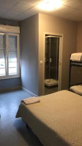 1 dormitorio con 1 cama y ducha a ras de suelo en Le Sporting, en Le Mans