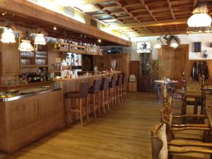 a bar in a restaurant with wooden floors and chairs at Tutzinger Hof in Tutzing