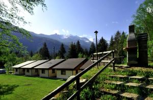 a building with mountains in the background with a fence at Chalet Presanella in Temù
