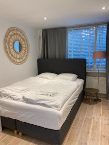 Una cama en un dormitorio con un espejo en la pared. en Studio Lief Bergen binnen, bij bos duin en dorp, en Bergen