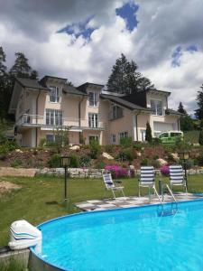 a house with a swimming pool in front of a house at Ferienwohnung Anita Benz in Thurmansbang