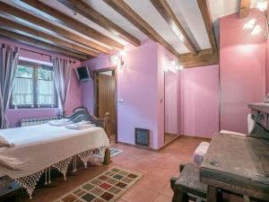 a bedroom with purple walls and a bed in a room at Hotel Rural Mañe in Mallavia