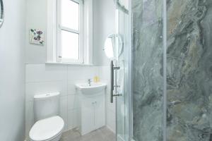 a bathroom with a toilet and a sink and a shower at Arthur's Seat View in Edinburgh +22 photos