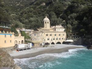 a building on the side of a beach with water at La Casa della Fiore in Camogli