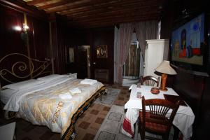 ein Schlafzimmer mit einem großen Bett und zwei Tischen in der Unterkunft Hotel Iliada in Tirana