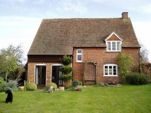 a small white house with a large window at Field Farm Cottage B&B in Reading