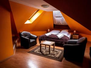 1 Schlafzimmer mit einem Bett, 2 Stühlen und einem Tisch in der Unterkunft Park UNESCO Residence in Łęknica