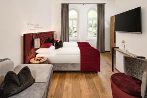 セルヴァ・ディ・ヴァル・ガルデーナにあるGrand Hotel Wolkensteinのベッドとソファ付きのホテルルーム
