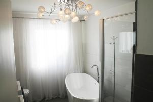 y baño con ducha, lavabo y lámpara de araña. en Haus Sonnenschein, en Lam 18 fotos más