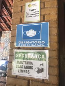 a group of signs on a brick wall at Pousada Nativo's in Nova Almeida
