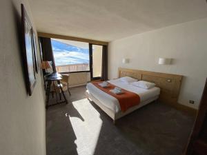 a hotel room with a bed and a large window at Hotel Le Portillo in Val Thorens