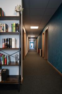 an office hallway with bookshelves and a hallway with a hallwayngthngthngth at Motel Q in Rottweil