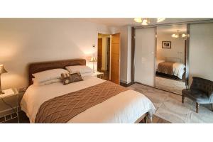 a bedroom with a large bed and a chair at Swans View - Sea Views and Beach 3 minutes walk in Falmouth