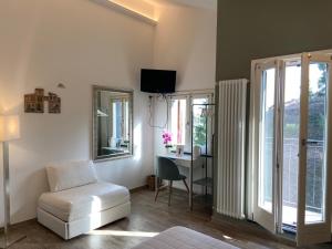 a living room with a white chair and a mirror at Hotel Il colle di Monterosso in Monterosso al Mare