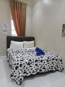 a black and white bed with a blue teddy bear on it at Desa Besut Inn in Kuala Besut