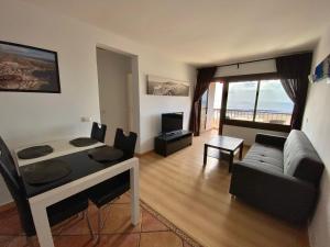 ein Wohnzimmer mit einem Sofa und ein Wohnzimmer mit einem Tisch in der Unterkunft Paradise Ocean View in Los Cristianos