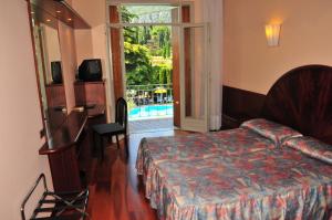 a hotel room with a bed and a view of a pool at Hotel Continental in Garda