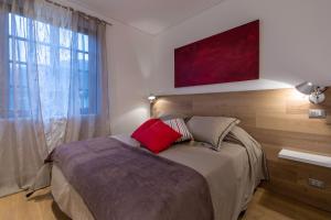Schlafzimmer mit einem Bett und einem Fenster mit einem roten Kissen in der Unterkunft Apartment Acero Rosso in Riccò del Golfo di Spezia