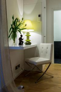 a desk with a chair and a lamp and a plant at Apartment Acero Rosso in Riccò del Golfo di Spezia