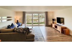 a living room with a couch and a tv at Swans View - Sea Views and Beach 3 minutes walk in Falmouth