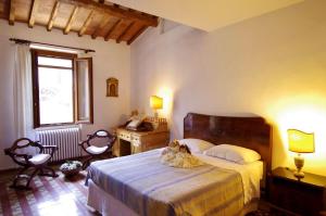 a bedroom with a bed and a desk and a window at Il Torrino in Barberino di Val dʼElsa