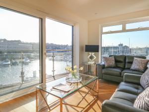 sala de estar con sofá y mesa de cristal en Harbourside Haven Apartment 3 en Weymouth