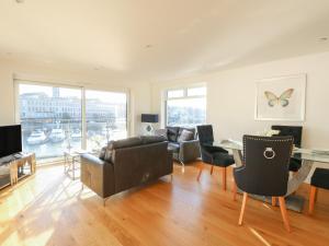 sala de estar con sofá, sillas y mesa en Harbourside Haven Apartment 3 en Weymouth