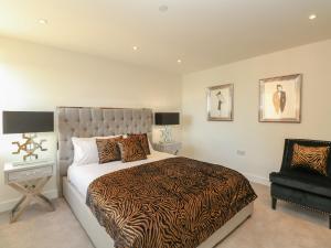 Un dormitorio con una cama grande y una silla. en Harbourside Haven Apartment 3, en Weymouth
