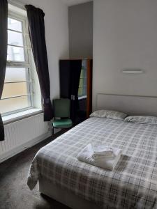 バロー・イン・ファーネスにあるThe Lodge Guest Accommodationのベッドと椅子と窓のある寝室
