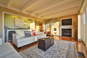 a living room with a white couch and a fireplace at Beach Nest! Hot Tub! Sauna! BBQ Grill! AMAZING VIEWS!! Romantic Getaway! Dog Friendly!! in Dillon Beach