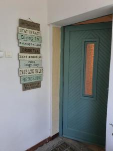 una puerta de garaje verde con letreros en la pared en Koppány Pines Rewild Escapes - The Lodge en Koppányszántó