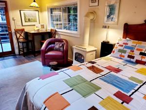 a bedroom with a bed with a colorful quilt on it at Guerneville Cottage! Redwoods! Hot Tub! Fire Table! Fast WiFi!! Serenity Defined! in Guerneville