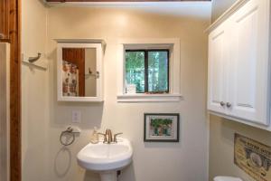 a bathroom with a white sink and a window at Guerneville Cottage! Redwoods! Hot Tub! Fire Table! Fast WiFi!! Serenity Defined! in Guerneville +11 photos