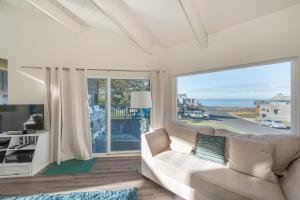 a living room with a couch and a large window at Knot-a-Care! Hot Tub!! Walk to Beach!! BBQ! Fast WiFi!! in Dillon Beach