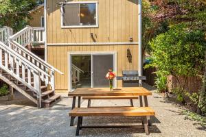 a picnic table with a vase of flowers on it at Happy Days! Downtown Guerneville! BBQ! Game Room!! Fast WiFi!! Dog Friendly! in Guerneville