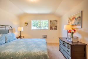 a bedroom with a bed and a dresser and a window at Happy Days! Downtown Guerneville! BBQ! Game Room!! Fast WiFi!! Dog Friendly! in Guerneville