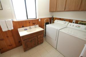 a small kitchen with a washer and a sink at Happy Days! Downtown Guerneville! BBQ! Game Room!! Fast WiFi!! Dog Friendly! in Guerneville +26 photos