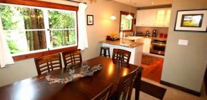 una cucina con un grande tavolo e sedie in legno di Little Red House! Redwoods! Hot Tub! BBQ! Fast WiFi!! Multiple Decks!! Near Golf Course!! Dog Friendly! a Guerneville