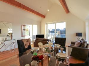a living room with a glass table and chairs at Harbourside Haven Penthouse 1 in Weymouth