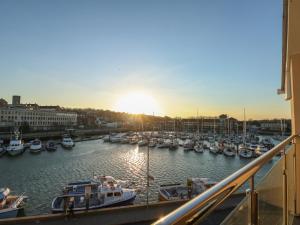 a group of boats docked in a harbor at sunset at Harbourside Haven Penthouse 1 in Weymouth