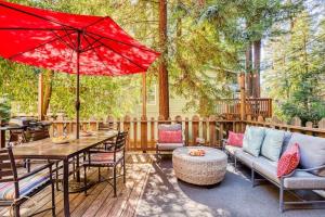 a patio with a table and a red umbrella at Redwood Retreat! Redwoods! Walk to River!! Hot Tub!! BBQ! Central Air!! in Guerneville