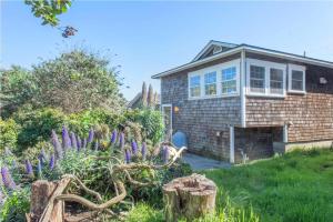a brick house with purple flowers in front of it at Sea Breeze! Walk to Beach!! In the Village! BBQ! Fast WiFi!! Dog Friendly! in Dillon Beach