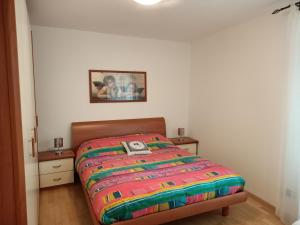 een bed met een kleurrijk dekbed in een slaapkamer bij Andalo 2000 in Andalo
